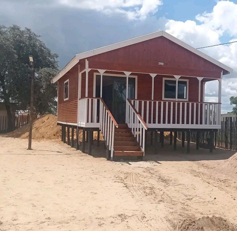Log home elevated on stilts with staircase and veranda