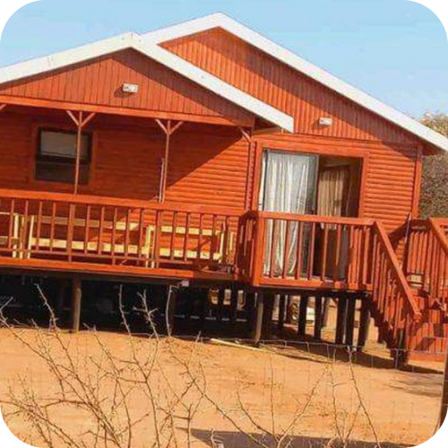 Log cabin with front wooden deck and exterior staircase on raised foundation